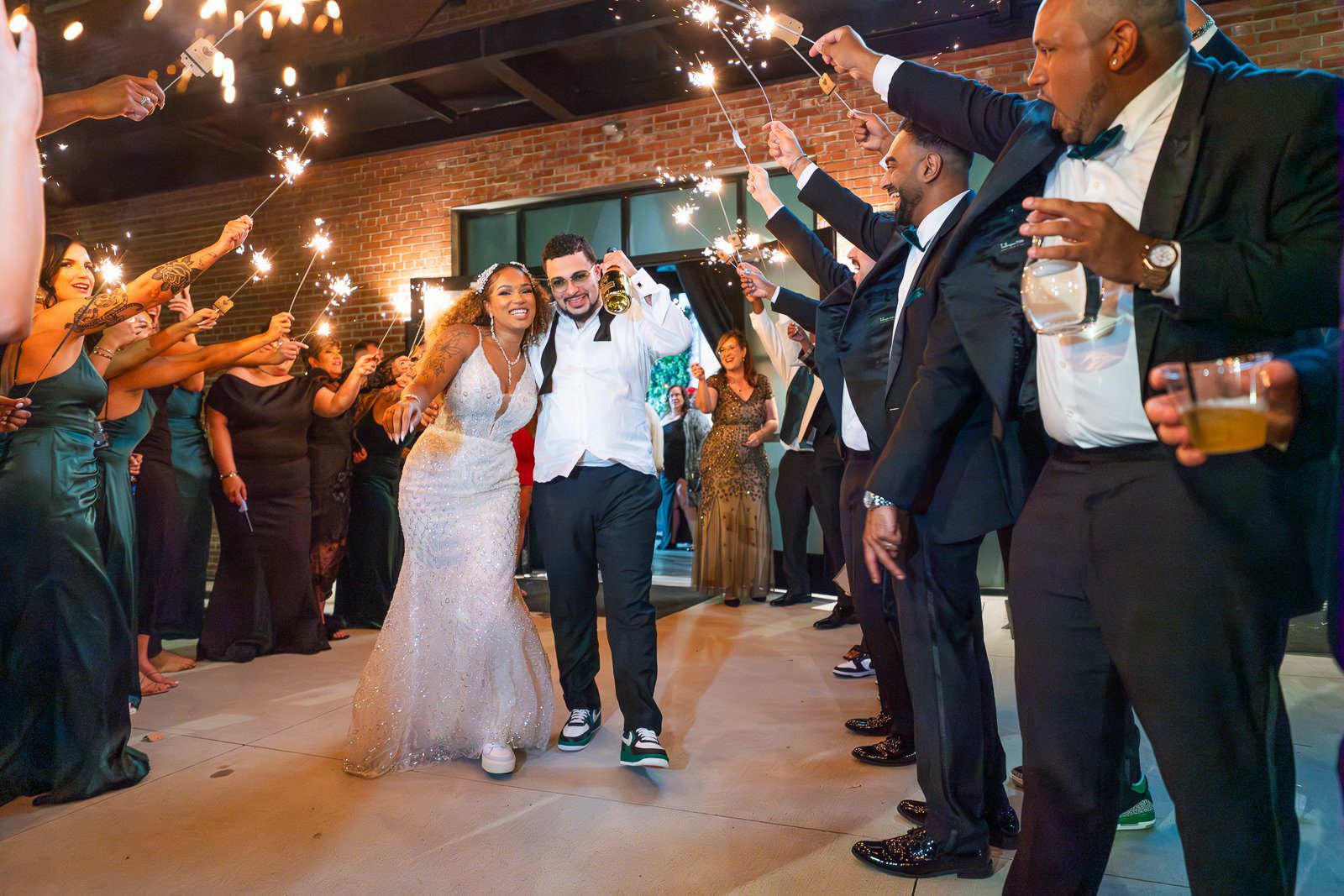 Newlyweds step into a sparkler-lit reception surrounded by friends and family