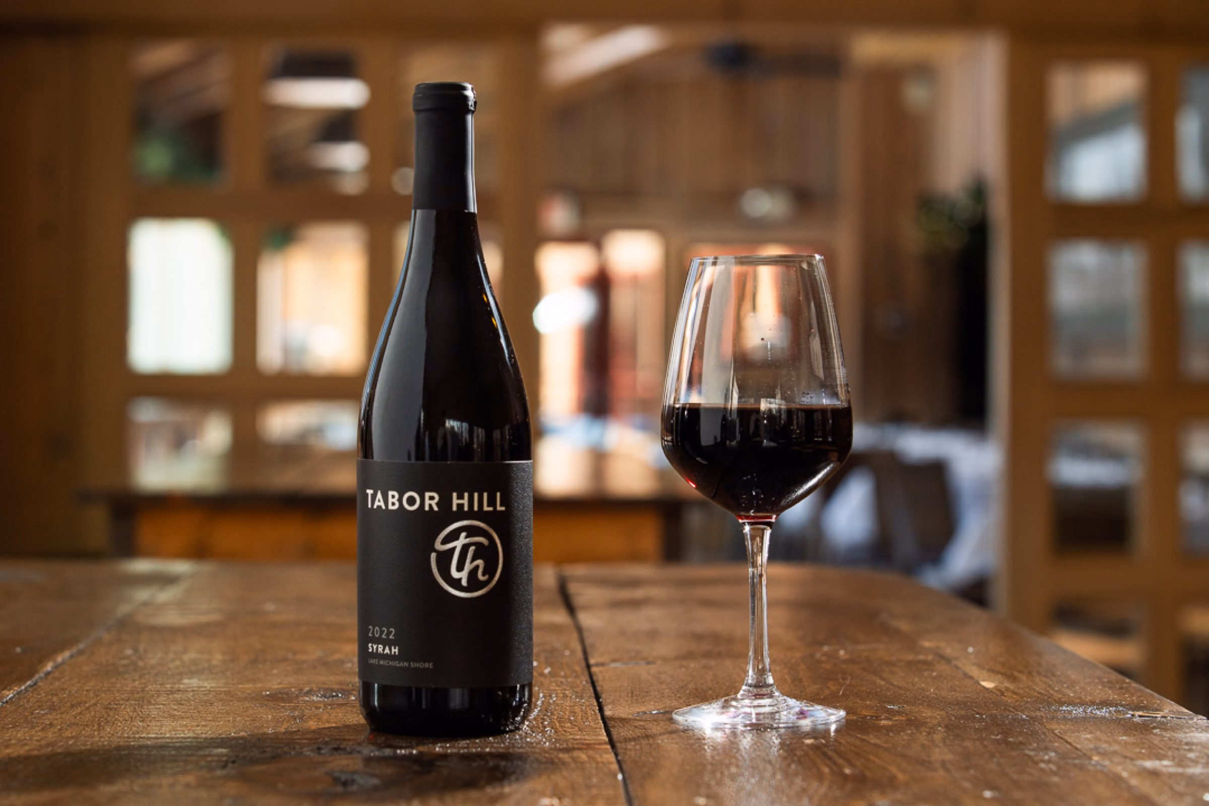 Tabor Hill red wine bottle and glass photographed in its restaurant setting