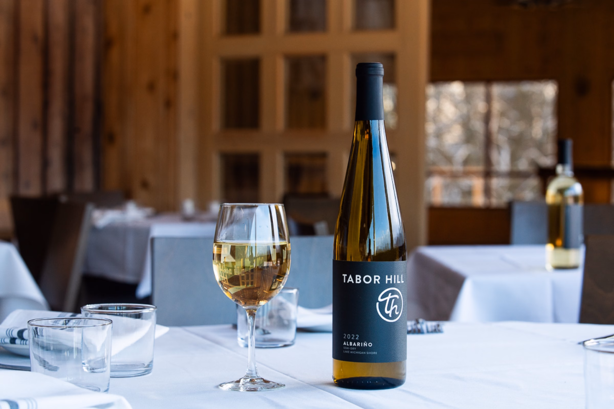 Tabor Hill white wine bottle and glass photographed in the restaurant